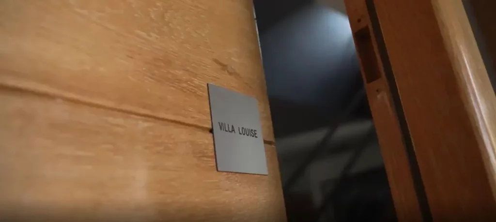 porte d'entrée ouverte en bois avec plaque villa louise